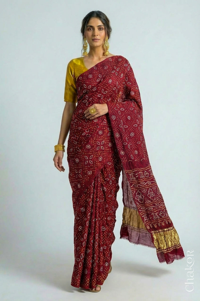 Woman wearing Handcrafted Maroon Bandhani Gaji Silk Saree with traditional rai bandhej patterns and mukaish embroidery.