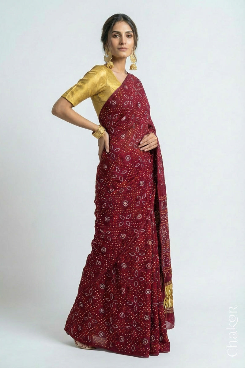Woman wearing Handcrafted Maroon Bandhani Gaji Silk Saree with traditional rai bandhej patterns and mukaish embroidery.