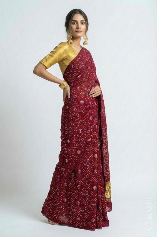 Woman wearing Handcrafted Maroon Bandhani Gaji Silk Saree with traditional rai bandhej patterns and mukaish embroidery.