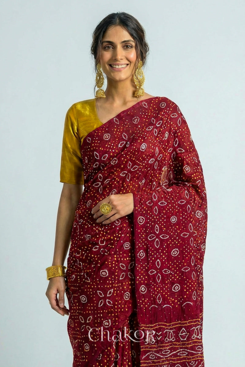 Woman wearing Handcrafted Maroon Bandhani Gaji Silk Saree with traditional rai bandhej patterns and mukaish embroidery.