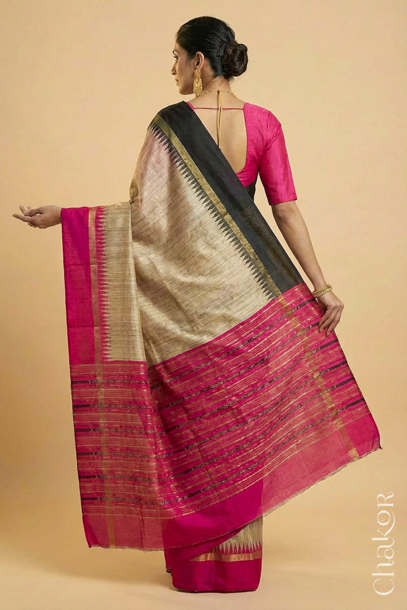 Back pose of Woman wearing a traditional pink and Natural tussar silk handloom temple border saree