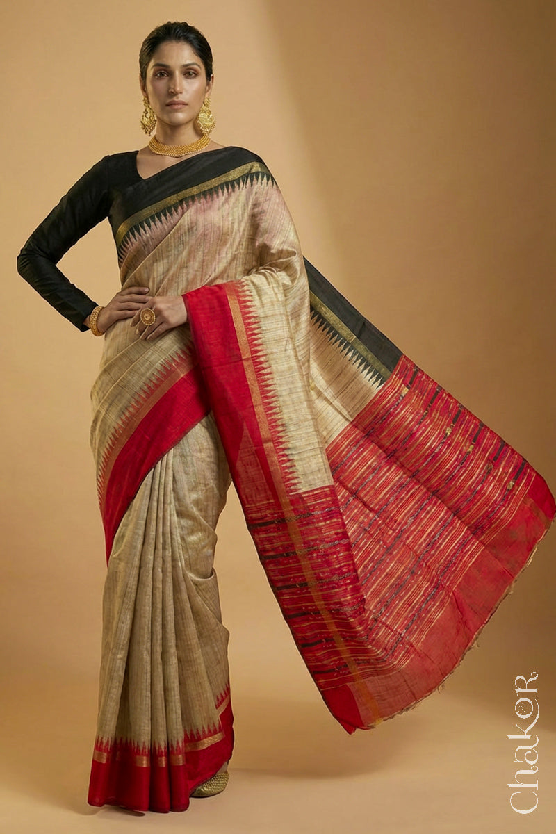 Woman wearing a traditional red and Natural tussar silk handloom temple border saree.