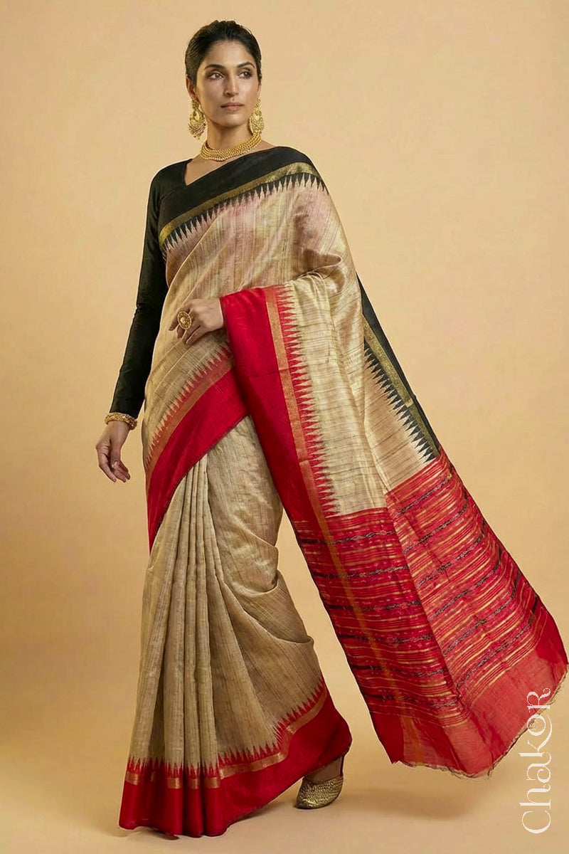Woman wearing a traditional red and Natural tussar silk handloom temple border saree.