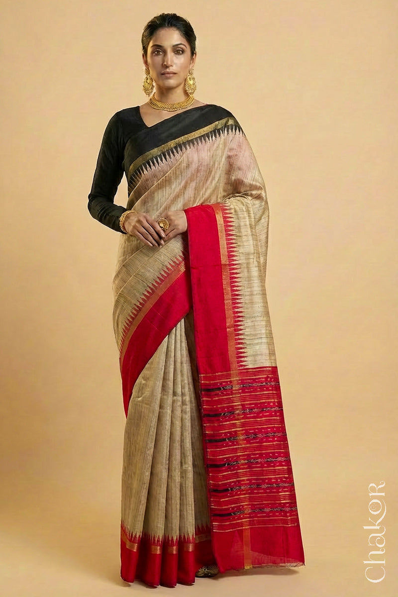 Woman wearing a traditional red and Natural tussar silk handloom temple border saree.