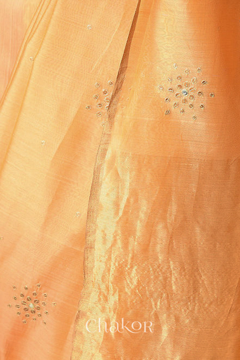 Close up of Peach Chanderi Silk Cotton Handloom Saree with sequins and mirror embroidery.