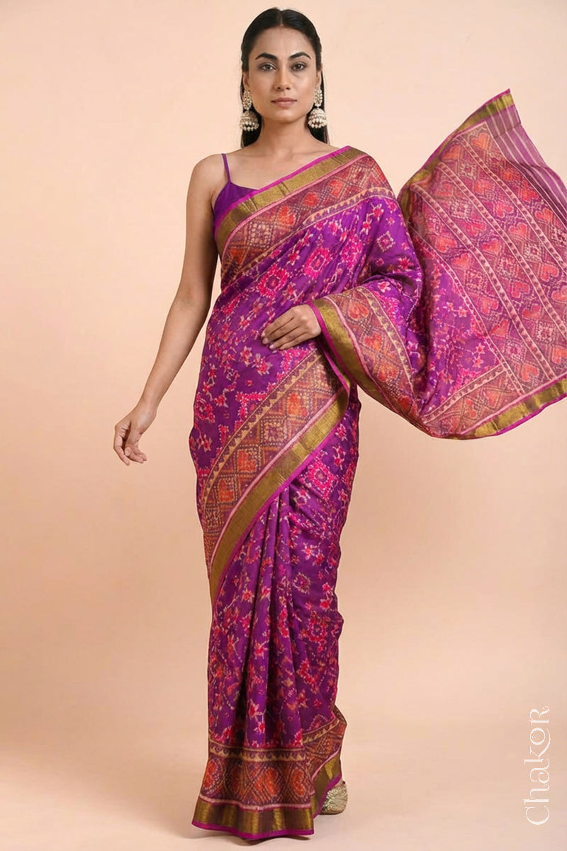 Model wearing Handloom Magenta Pink Rajkoti Patola Ikat Mulberry Silk Saree with tissue borders, woven using traditional designs in Gujarat.