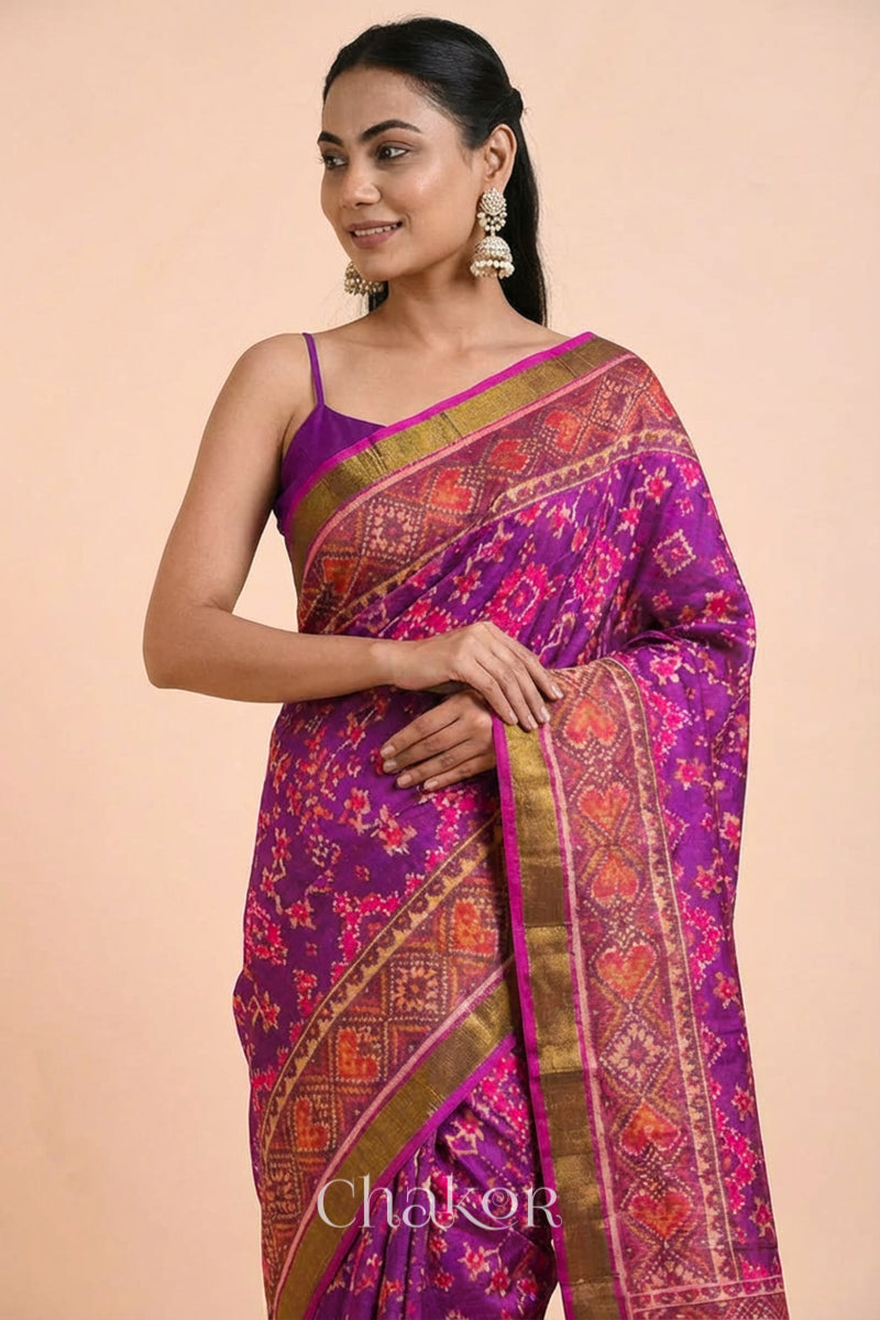 Model wearing Handloom Magenta Pink Rajkoti Patola Ikat Mulberry Silk Saree with tissue borders, woven using traditional designs in Gujarat.