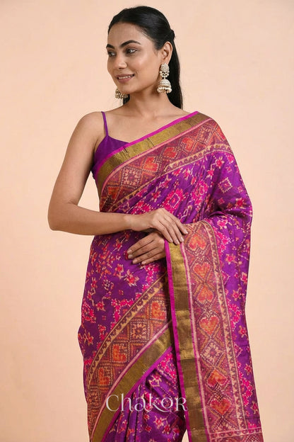 Model wearing Handloom Magenta Pink Rajkoti Patola Ikat Mulberry Silk Saree with tissue borders, woven using traditional designs in Gujarat.