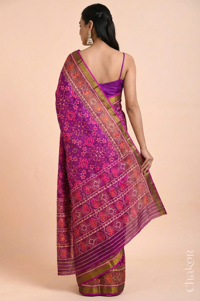 Model wearing Handloom Magenta Pink Rajkoti Patola Ikat Mulberry Silk Saree with tissue borders, woven using traditional designs in Gujarat.
