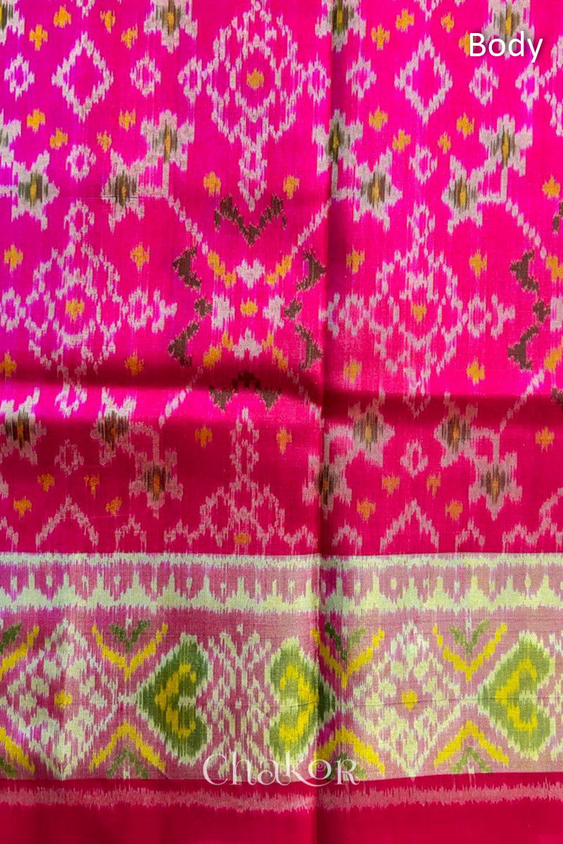 Close up of Handloom Rani Pink Rajkoti Patola Ikat Mulberry Silk Saree with tissue borders, and mauve pallu woven using traditional designs in Gujarat.
