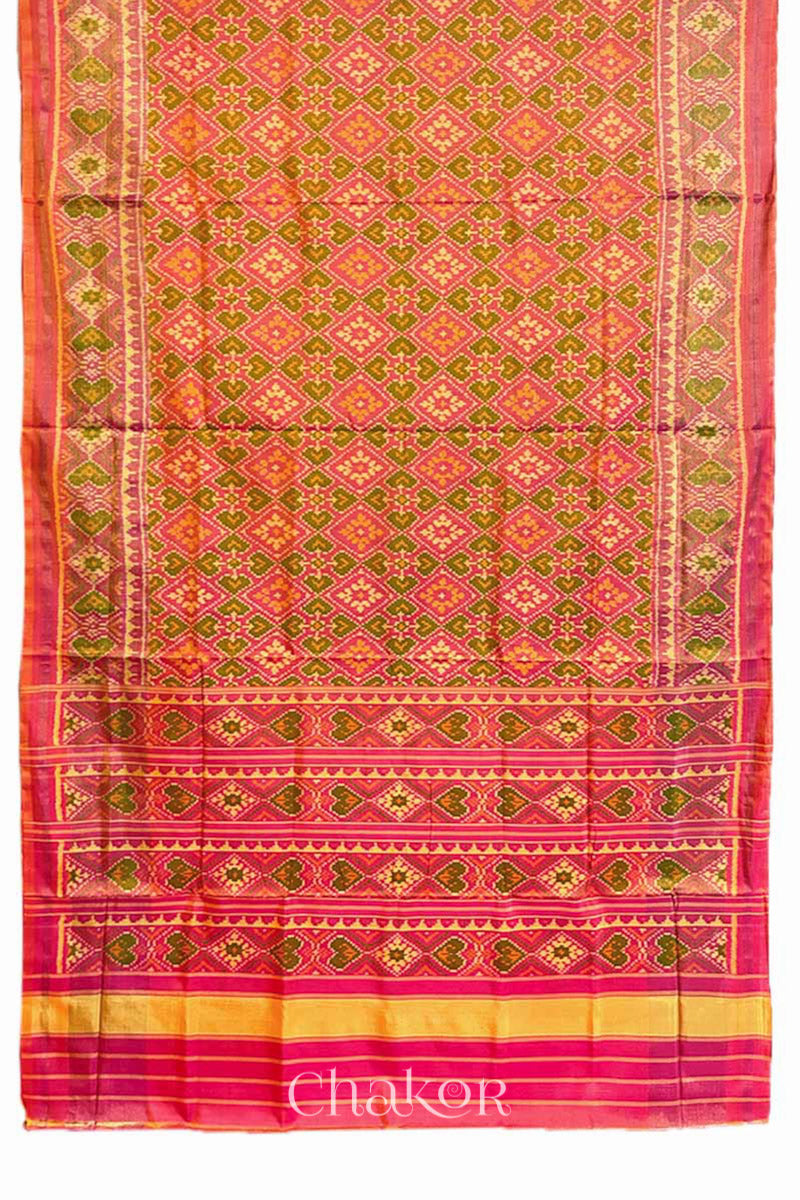 Full view of Handloom Coral Peach Rajkoti Patola Ikat Mulberry Silk Saree with tissue borders, and pink pallu woven using traditional designs in Gujarat.
