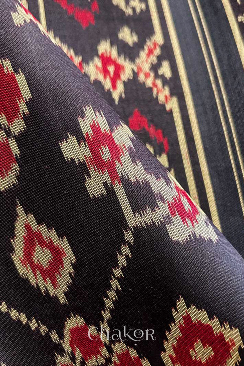 Close up of Handloom Black Patola Ikkat Mulberry Silk Saree with traditional patterns in red floral motifs.