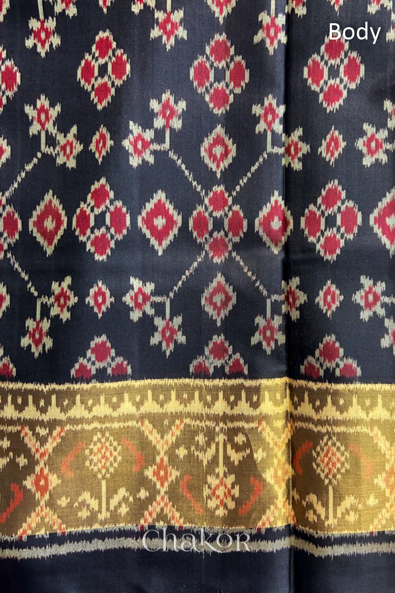 Body detail of Handloom Black Patola Ikkat Mulberry Silk Saree with traditional patterns in red floral motifs.
