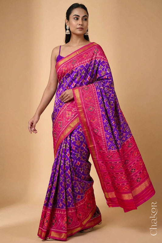 Model wearing Handloom Purple Pink Ikat Patola Mulberry Silk Saree with traditional design.