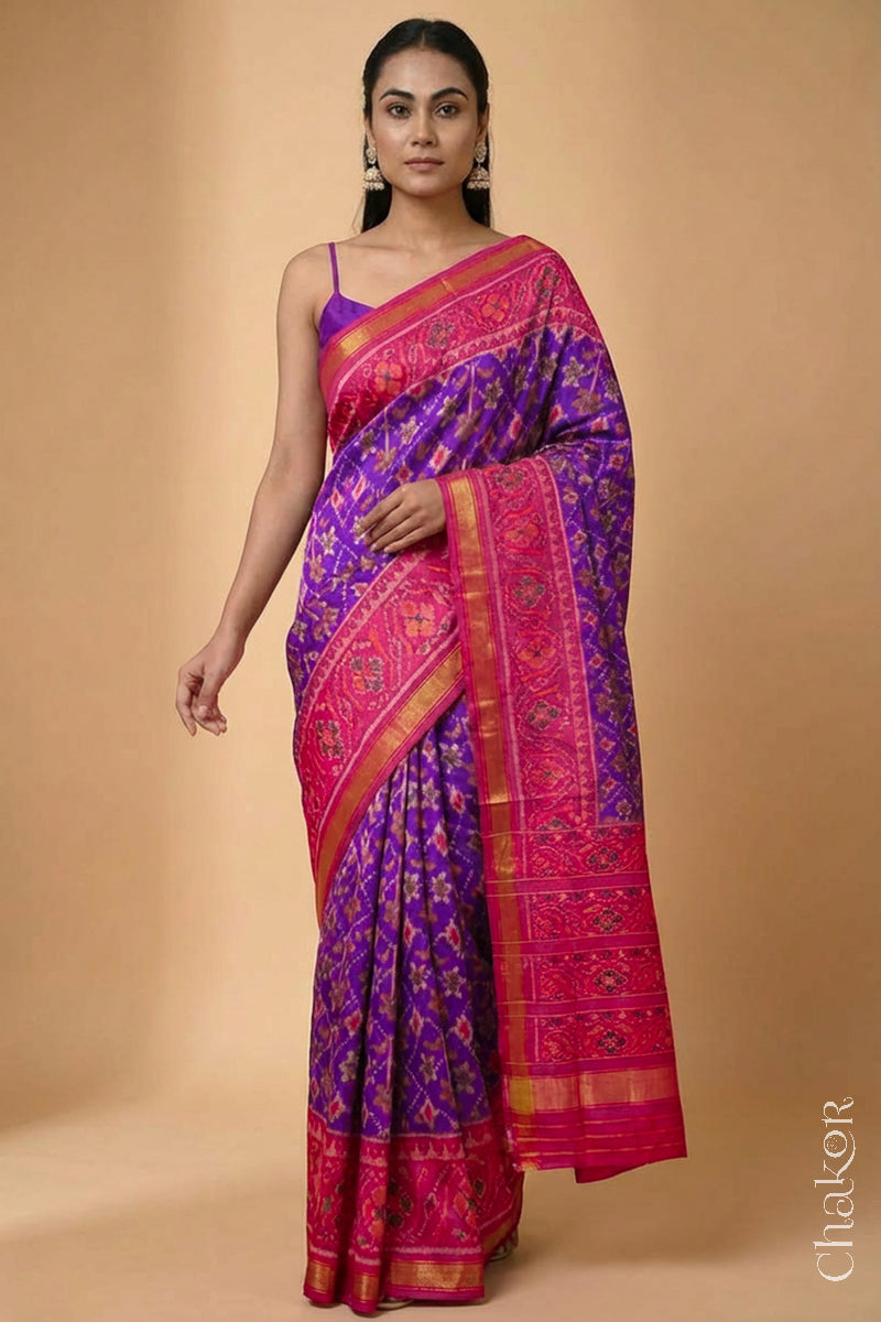 Model wearing Handloom Purple Pink Ikat Patola Mulberry Silk Saree with traditional design.