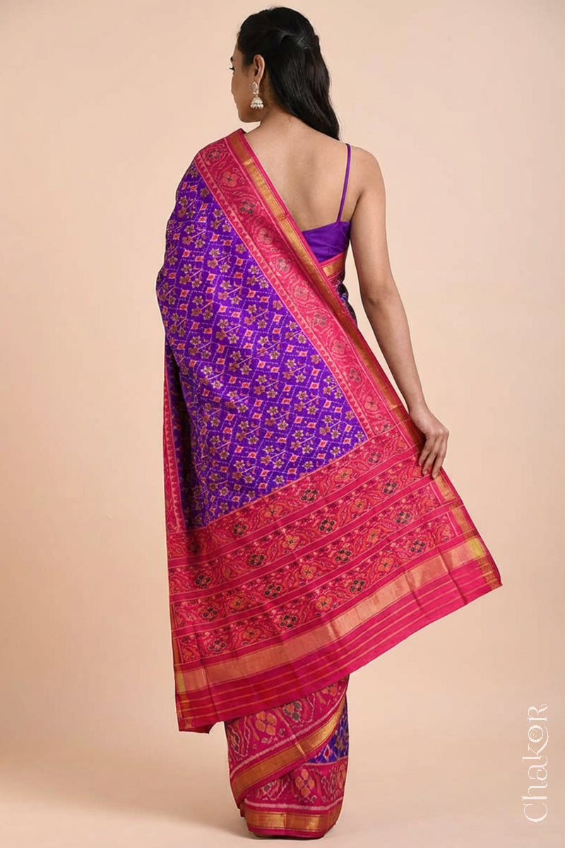 Model wearing Handloom Purple Pink Ikat Patola Mulberry Silk Saree with traditional design.