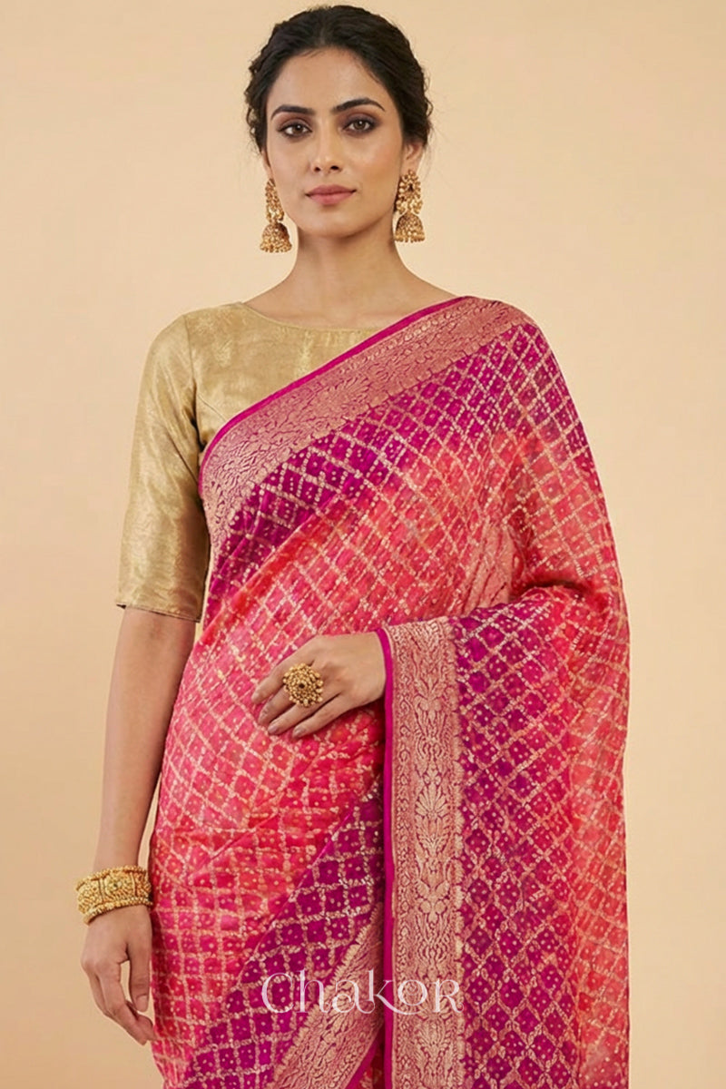 Woman wearing Handcrafted Pink and peach ombre shaded Bandhani Banarasi Georgette Silk Saree featuring zari weaving and Kutch Bandhej.