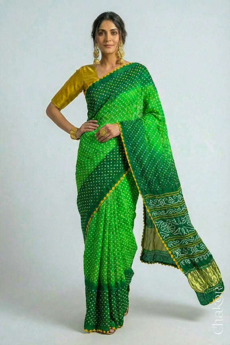 Woman wearing Handcrafted Parrot and green ombre Bandhani Gaji Silk Saree with traditional bandhej patterns and mukaish embroidery.