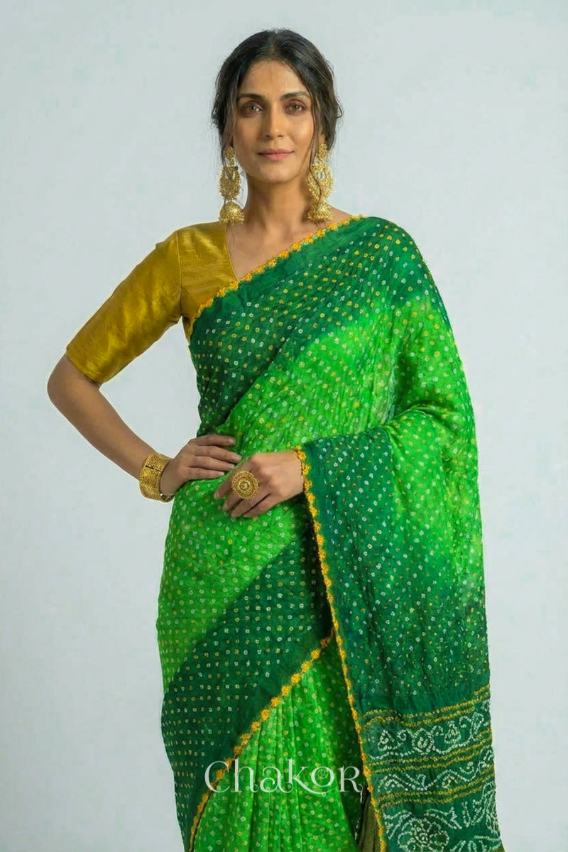 Woman wearing Handcrafted Parrot and green ombre Bandhani Gaji Silk Saree with traditional bandhej patterns and mukaish embroidery.