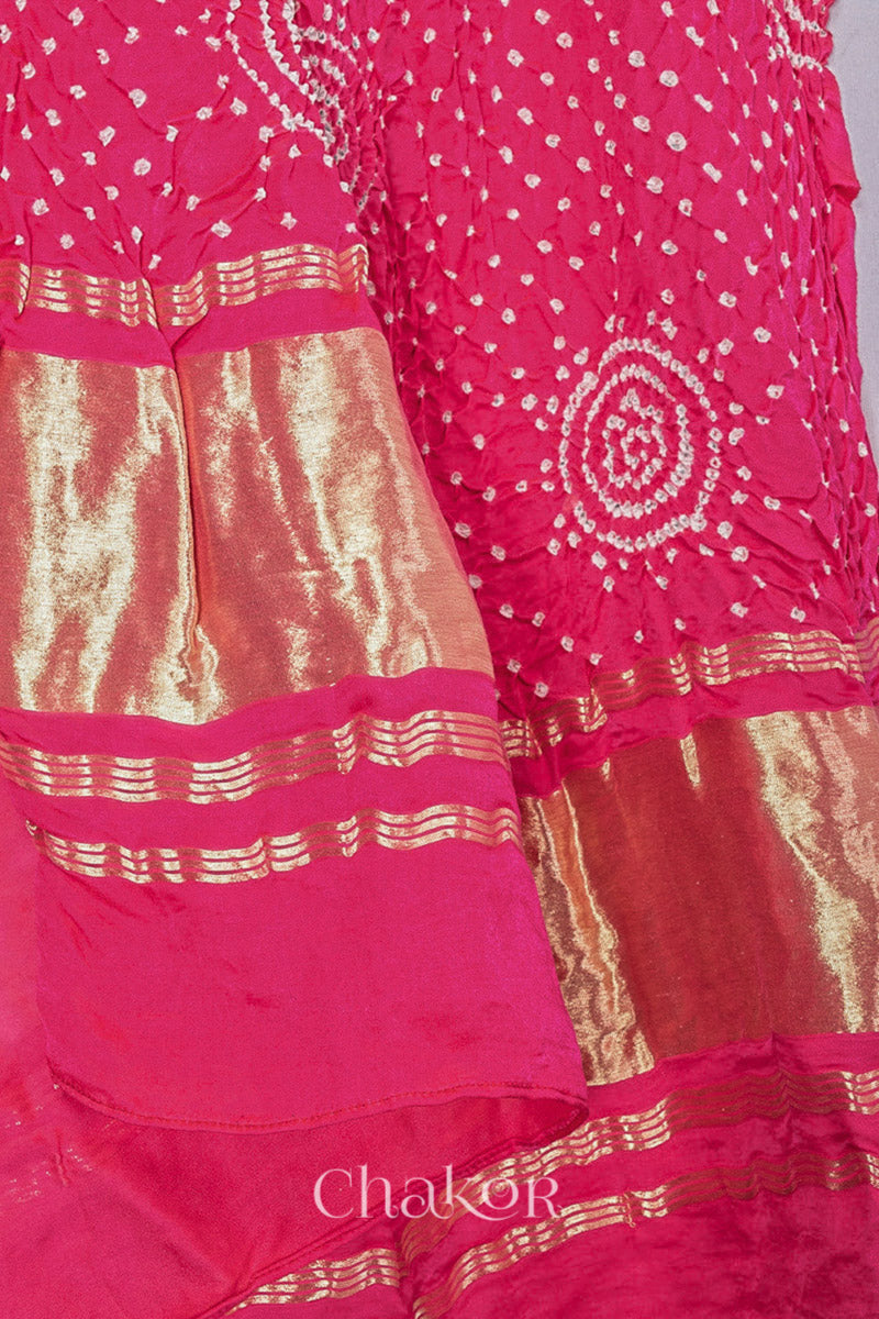 Angled detail of coral Bandhani gaji silk dupatta showing circular motifs and tissue band border.
