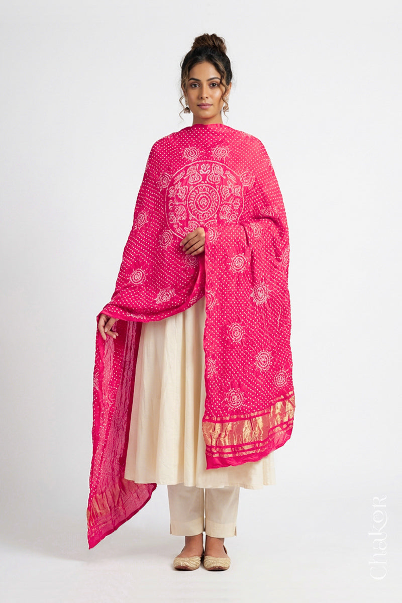 Model wearing coral Bandhani gaji silk dupatta with Raas Mandal pattern and lagdi patto pallu.