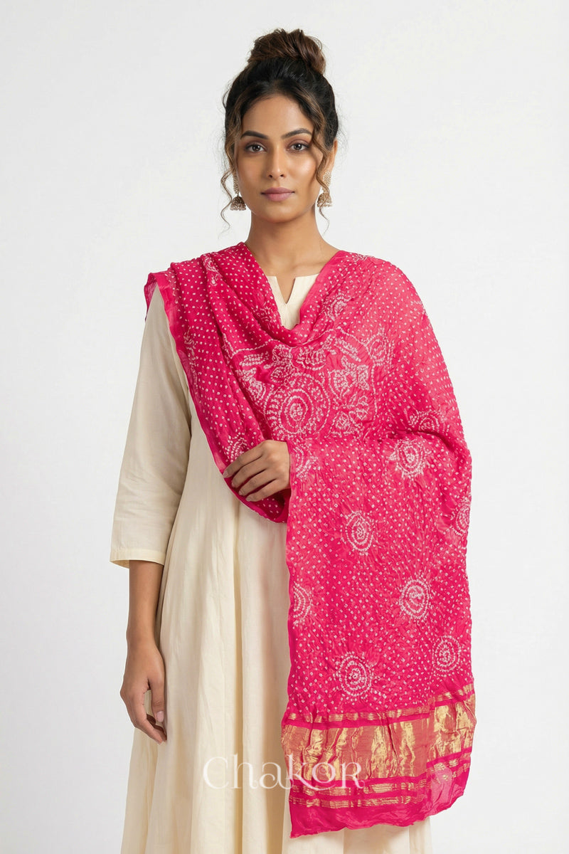 Close up of model wearing coral Bandhani gaji silk dupatta with Raas Mandal pattern and lagdi patto pallu.