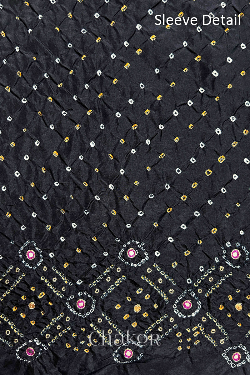 Sleeve detail of Black mulberry silk Bandhani (Rai Bandhej) fabric with white and yellow butis, geometric bandhej borders and pink with zari mirror embroidery – CHAKOR.
