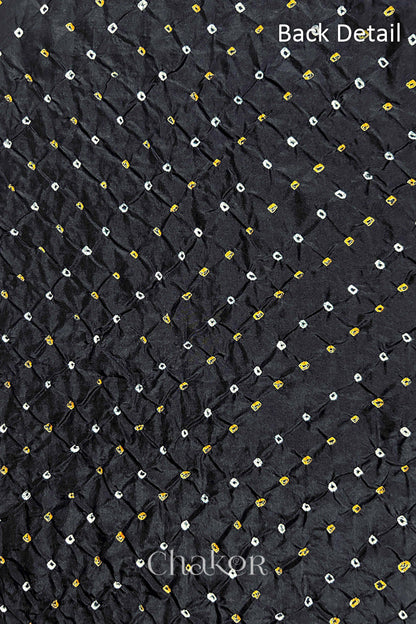 Back detail of Black mulberry silk Bandhani (Rai Bandhej) fabric with white and yellow tie-dye butis in an all-over pattern – CHAKOR.
