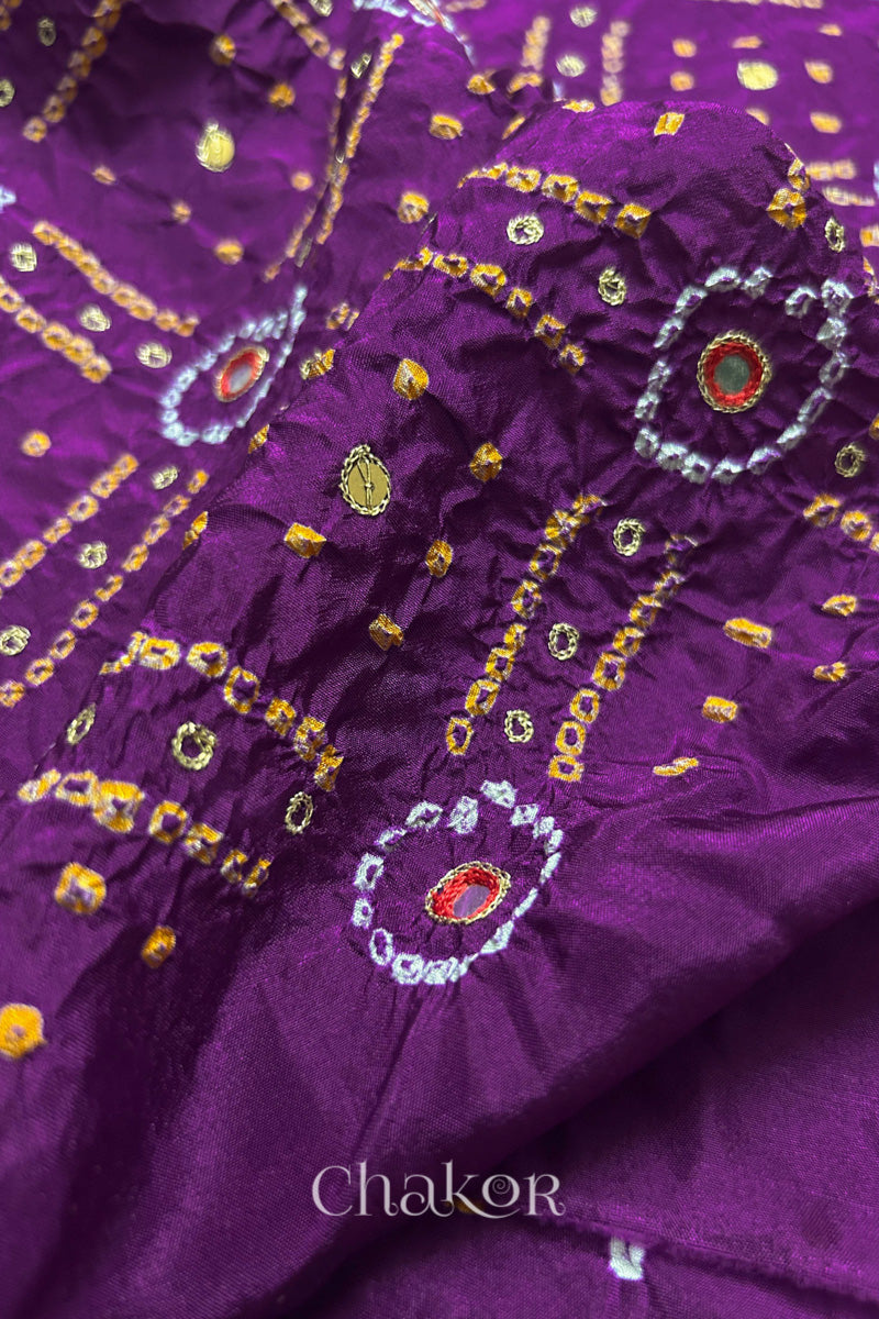 Close-up of Purple mulberry silk Bandhani (Rai Bandhej) fabric with white and yellow tie-dye motifs, red embroidered mirror work and sequin detailing – CHAKOR.
