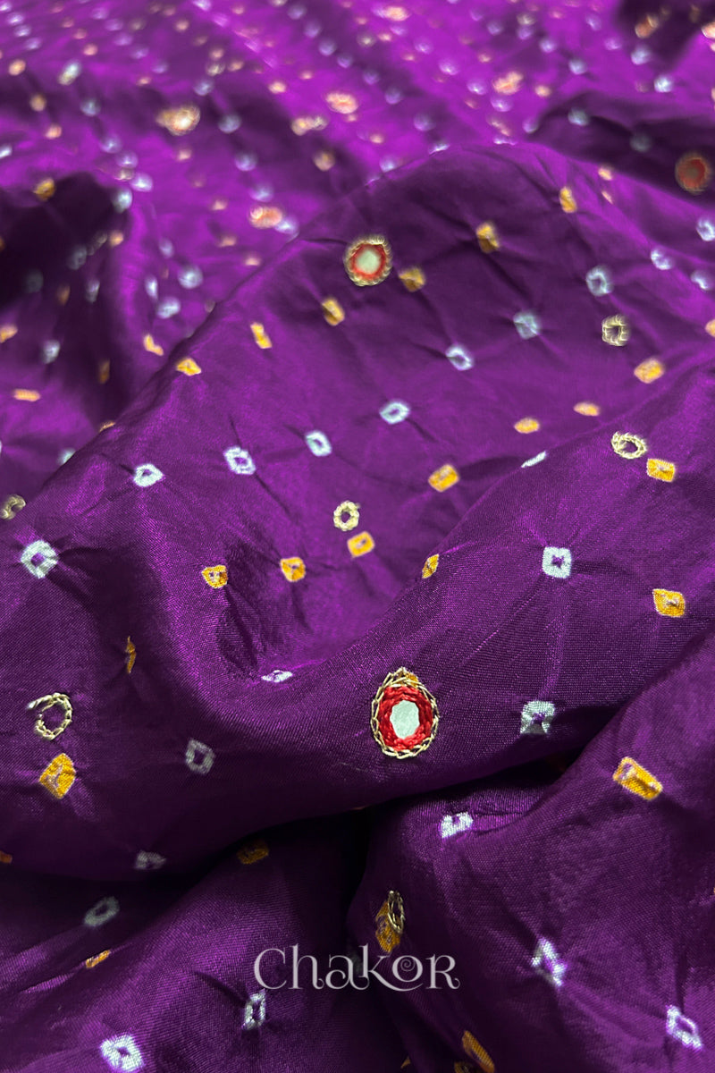 Close-up of Purple mulberry silk Bandhani (Rai Bandhej) fabric with white and yellow tie-dyed butis and a red embroidered mirror motif – CHAKOR.
