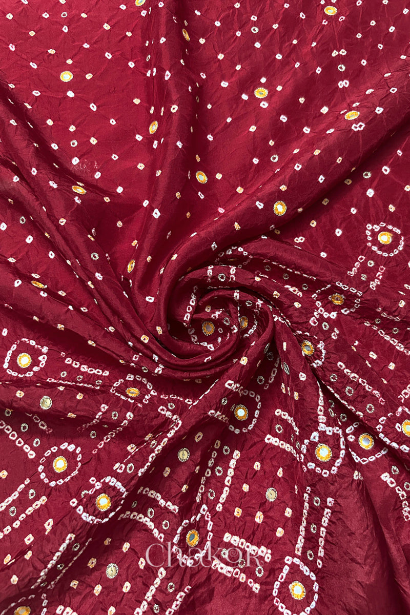 Deep Red mulberry silk Bandhani (Rai Bandhej) fabric with white and yellow tie-dyed motifs, yellow with zari mirror and sequin embellishment, arranged in a swirling design  – CHAKOR.
