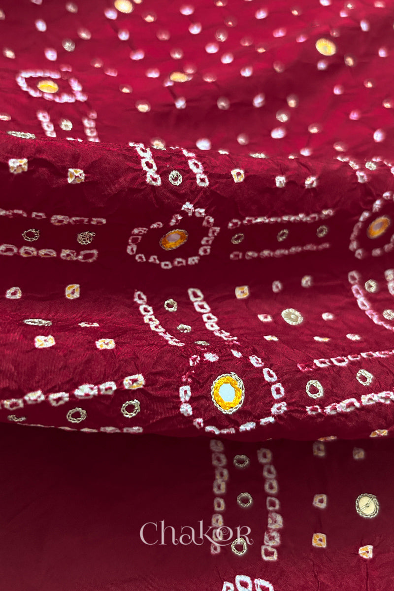 Close-up of Deep Red mulberry silk Bandhani (Rai Bandhej) fabric with white and yellow tie-dye motifs, yellow with zari embroidered mirror work and sequin detailing – CHAKOR.