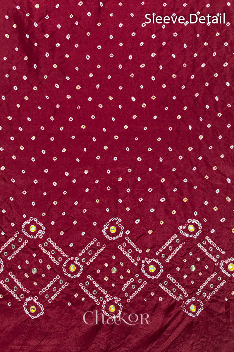 Sleeve detail of Deep Red mulberry silk Bandhani (Rai Bandhej) fabric with white and yellow butis, geometric bandhej borders and yellow with zari mirror embroidery – CHAKOR.
