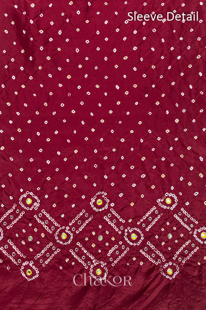 Sleeve detail of Deep Red mulberry silk Bandhani (Rai Bandhej) fabric with white and yellow butis, geometric bandhej borders and yellow with zari mirror embroidery – CHAKOR.
