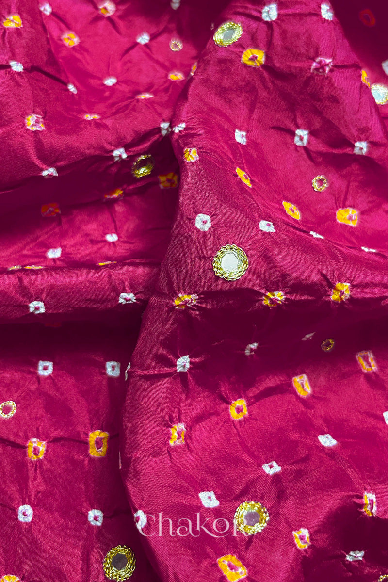 Close-up of Rani Pink mulberry silk Bandhani (Rai Bandhej) fabric with white and yellow tie-dyed butis and a golden zari embroidered mirror motif – CHAKOR.