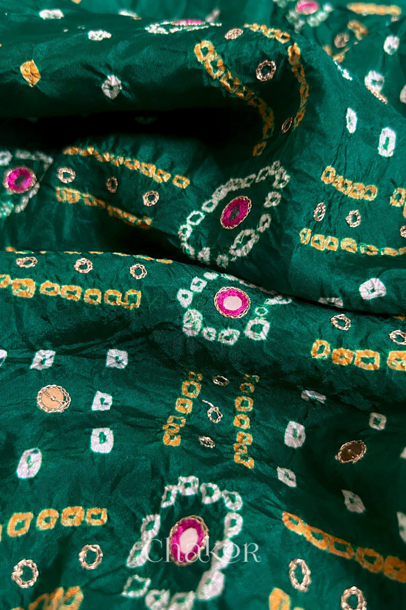 Close-up of green mulberry silk Bandhani (Rai Bandhej) fabric with white and yellow tie-dye motifs, pink embroidered mirror work and sequin detailing – CHAKOR.