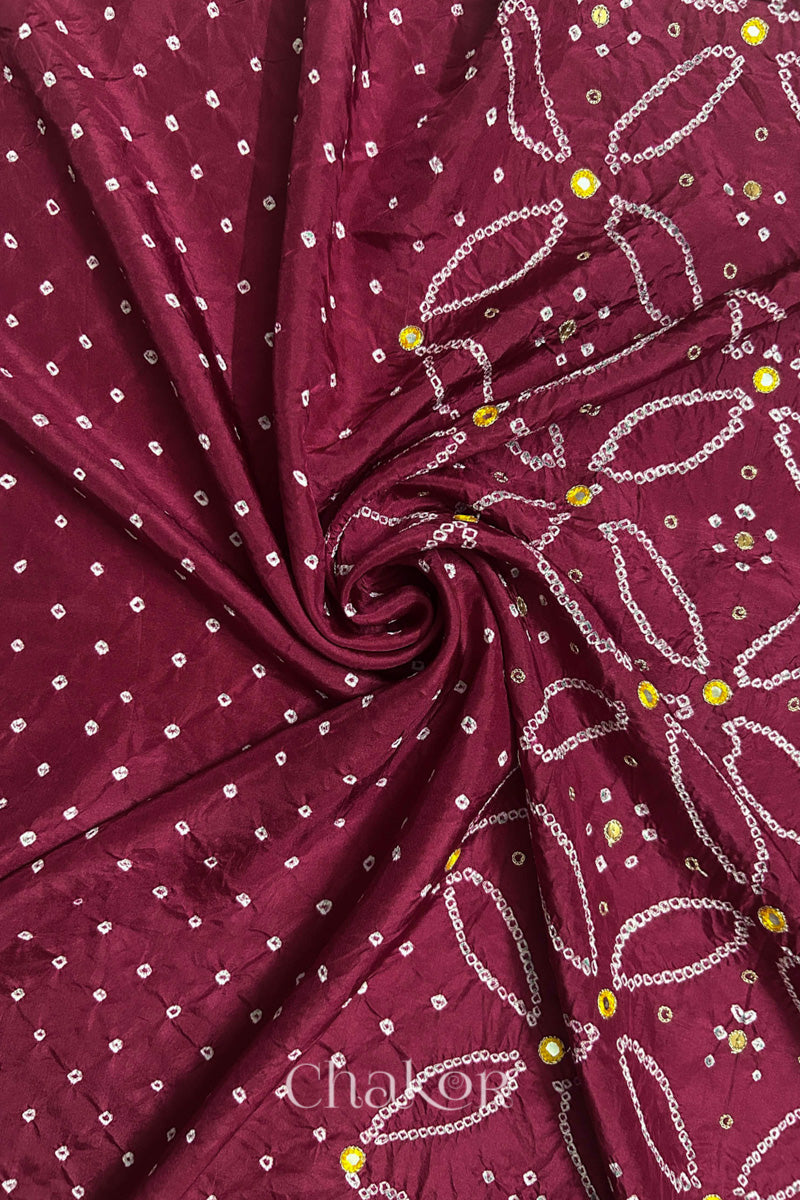 Dusty Red mulberry silk Bandhani (Rai Bandhej) fabric with white tie-dyed motifs, yellow with zari mirror and sequin embellishment, arranged in a swirling design  – CHAKOR.
