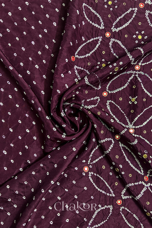 Maroon mulberry silk Bandhani (Rai Bandhej) fabric with white tie-dyed motifs, zari embroidered red mirror and sequin embellishment, arranged in a swirling design  – CHAKOR.