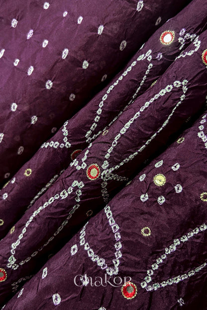 Close-up of Maroon mulberry silk Bandhani (Rai Bandhej) fabric with white tie-dye motifs, zari embroidered red mirror work and sequin detailing – CHAKOR.
