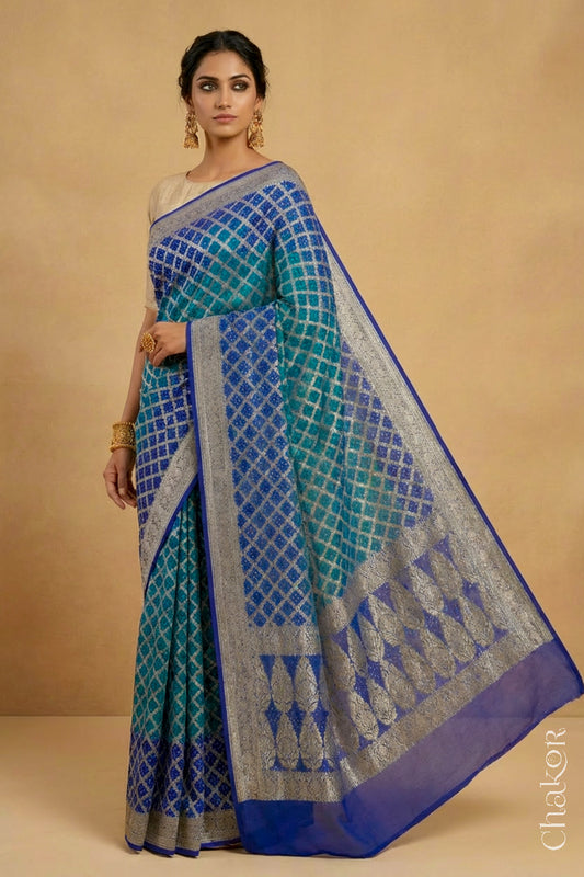 Woman wearing Handcrafted Peacock Blue  Bandhani Banarasi Georgette Silk Saree featuring zari weaving and kutch rai bandhej.