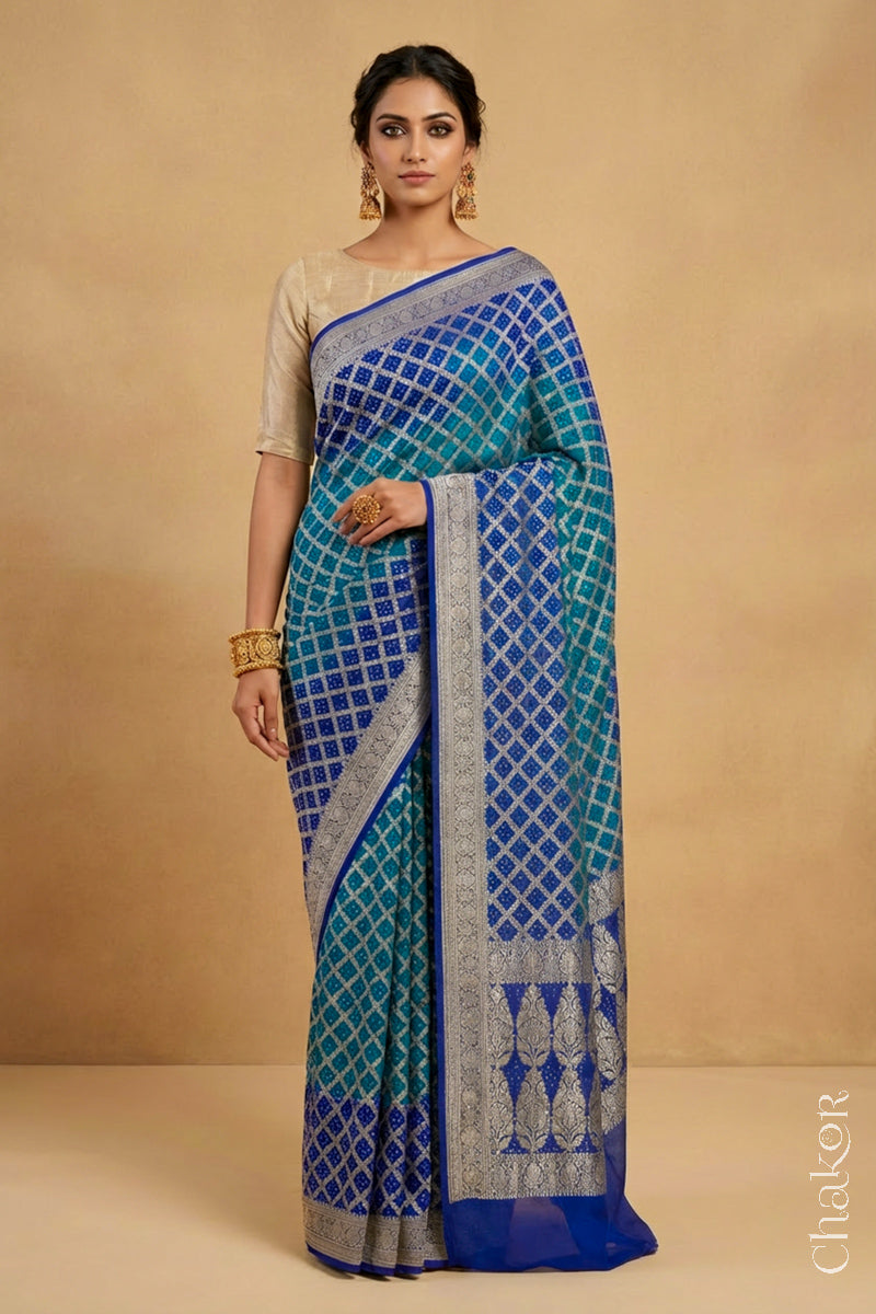 Woman wearing Handcrafted Peacock Blue  Bandhani Banarasi Georgette Silk Saree featuring zari weaving and kutch rai bandhej.
