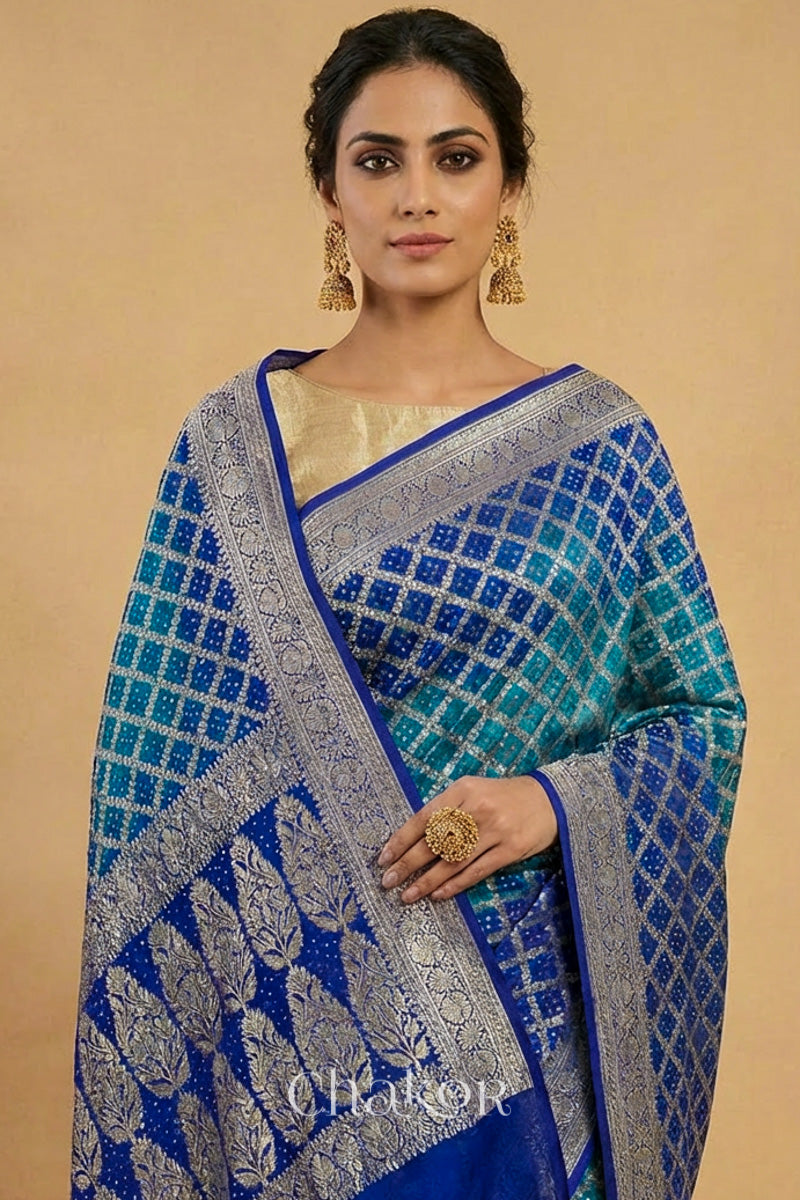 Woman wearing Handcrafted Peacock Blue  Bandhani Banarasi Georgette Silk Saree featuring zari weaving and kutch rai bandhej.