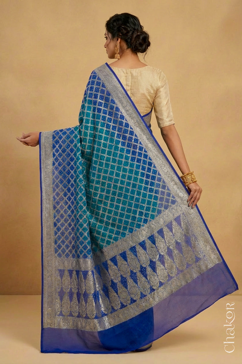 Woman wearing Handcrafted Peacock Blue  Bandhani Banarasi Georgette Silk Saree featuring zari weaving and kutch rai bandhej.
