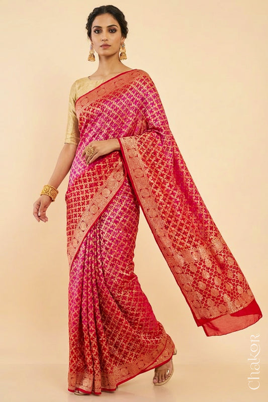 Woman wearing Handcrafted Pink Red ombre shaded Bandhani Banarasi Georgette Saree in pure silk featuring zari weaving and Kutch Bandhej for weddings and occasions.