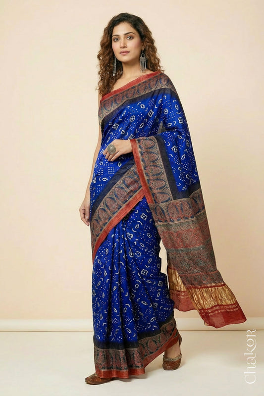 Woman wearing Blue Bandhani Saree with Red Ajrakh printed border and pallu in pure gaji silk with traditional bandhej tie-dye, handcrafted in Kutch. 