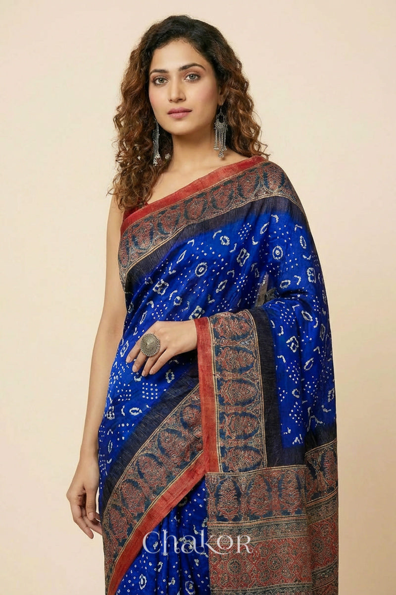 Woman wearing Blue Bandhani Saree with Red Ajrakh printed border and pallu in pure gaji silk with traditional bandhej tie-dye, handcrafted in Kutch. 