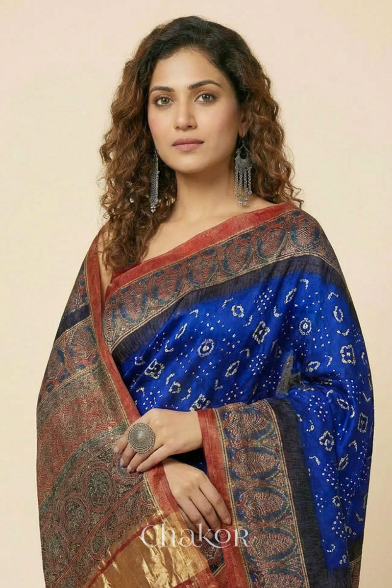 Woman wearing Blue Bandhani Saree with Red Ajrakh printed border and pallu in pure gaji silk with traditional bandhej tie-dye, handcrafted in Kutch. 