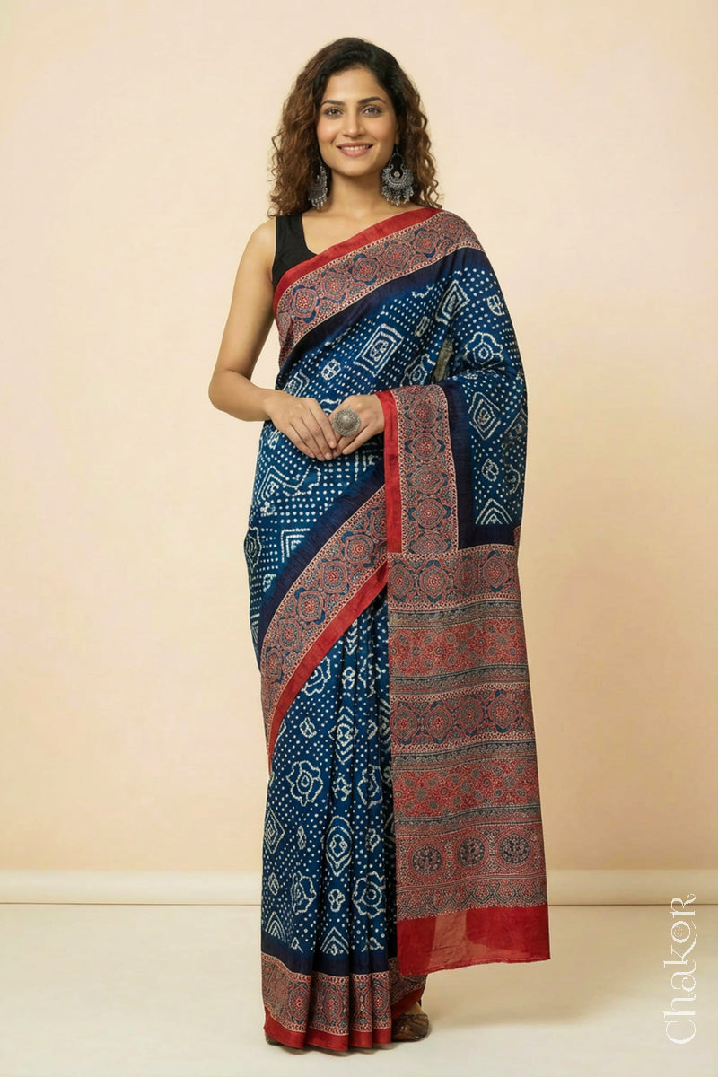 Woman wearing Navy Bandhani Saree with Red Ajrakh printed border and pallu in pure gaji silk with traditional bandhej tie-dye, handcrafted in Kutch. 