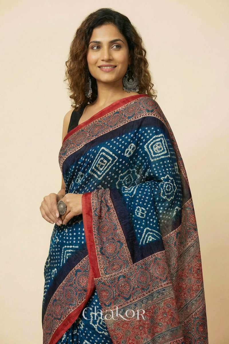 Woman wearing Navy Bandhani Saree with Red Ajrakh printed border and pallu in pure gaji silk with traditional bandhej tie-dye, handcrafted in Kutch. 