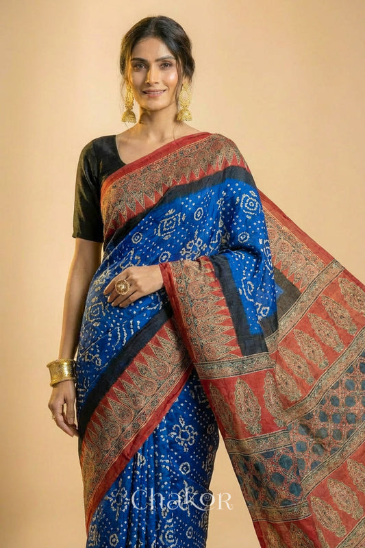 Woman wearing Blue Bandhani Saree with Natural Red Ajrakh printed border and pallu in pure gaji silk with traditional bandhej tie-dye, handcrafted in Kutch. 